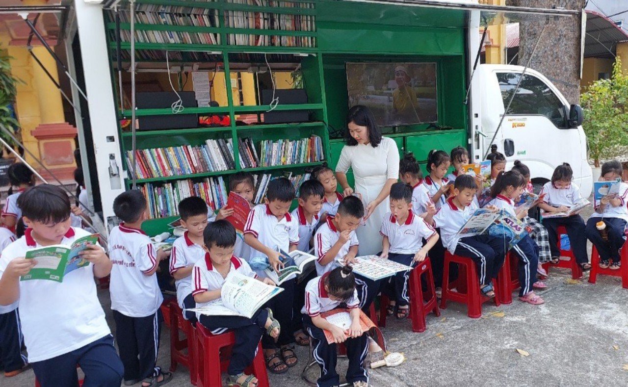 Description: A group of children reading booksDescription automatically generated